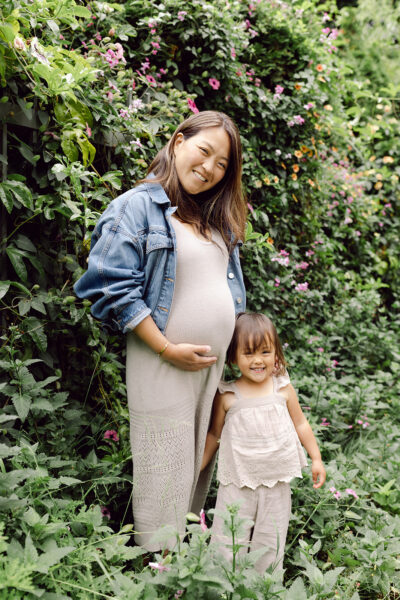 Dr. Renie Ikeda and her daughter smiling in a garden, expecting baby #2